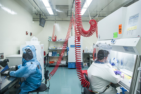 Infectious disease researchers Elke Mühlberger (left) and Adam Hume conduct BSL-4 research at Boston University's National Emerging Infectious Diseases Laboratories (NEIDL).