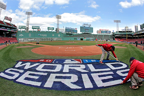 Grounds crew members paint the World Series logo behind home plate at Fenway Park, Sunday, Oct. 21, 2018, as they prepare for Game 1 of the baseball World Series.