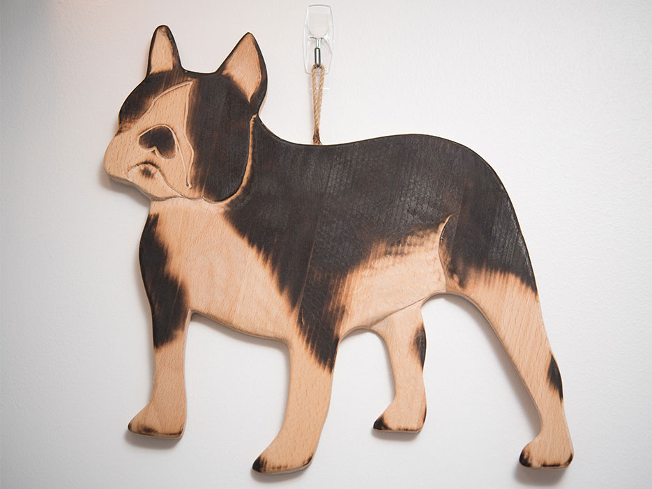 A wooden carving of a terrier hanging on the wall of a Boston University dorm.