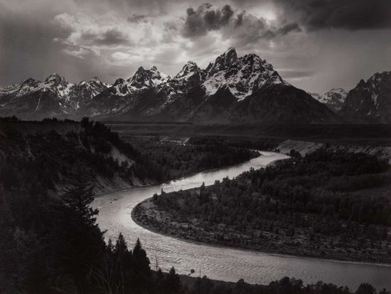  a black and white photograph of a mountain and river