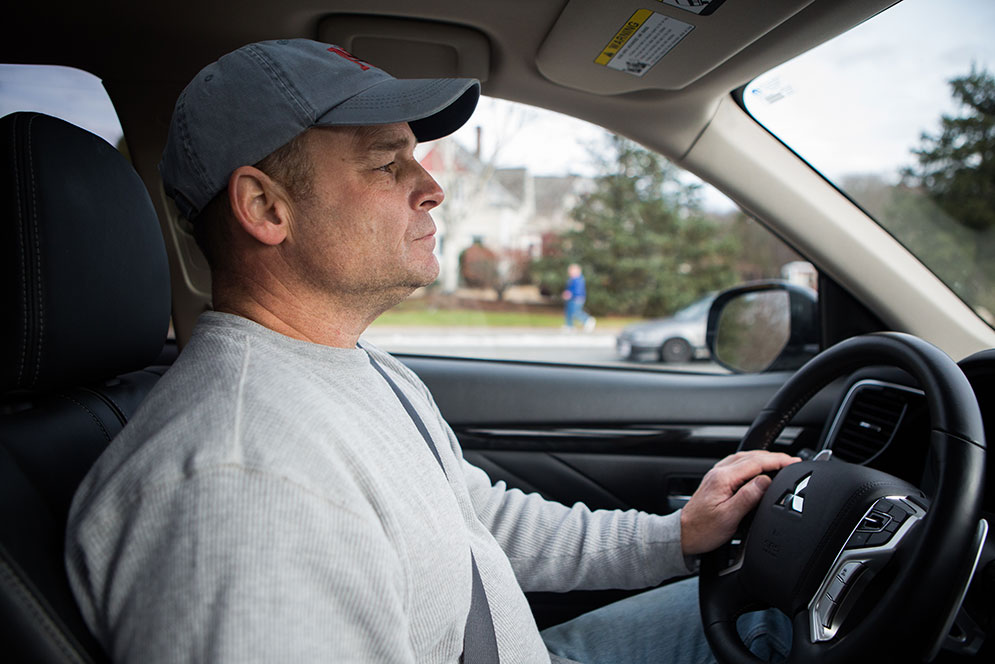 Cockpit view of Mike Wagner driving his Mitsubishi Outlander PHEV hybrid vehicle.