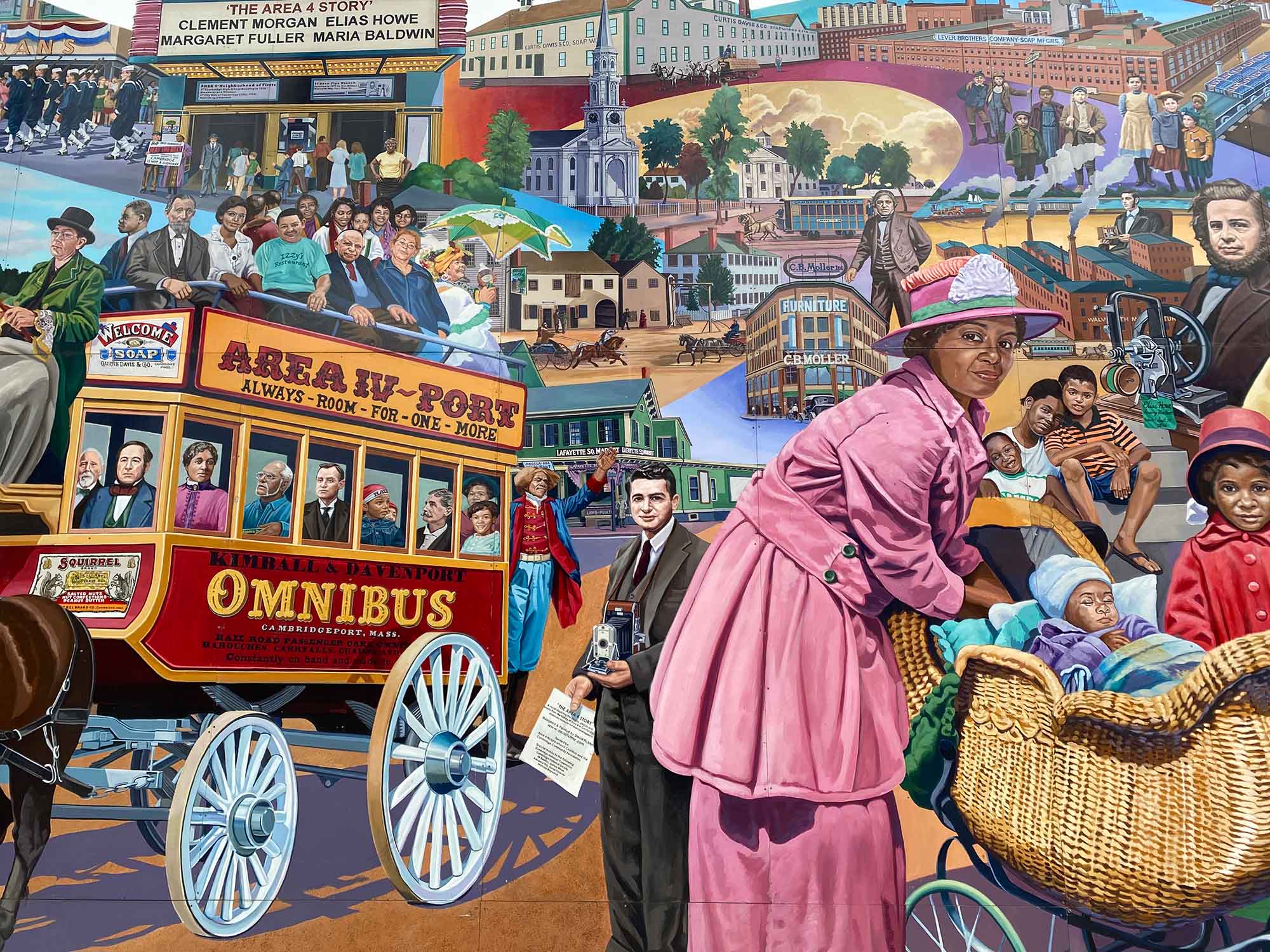 Photo of a mural that shows various illustrations of various scenes of people of all races, ethnicities, and gender out and about Kendall Square. The colorful mural shows the scenes in different time periods together. 