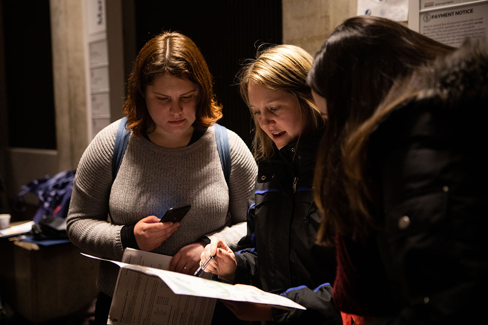 Kate King, Deputy Director of the Mayor's Office of Intergovermental Relations, center, helps BU School of Public Health student volunteers Danielle McPeak, left, and Meghan Smith, right, map out their route to reach out to the homeless during the annual Boston Homeless Census.