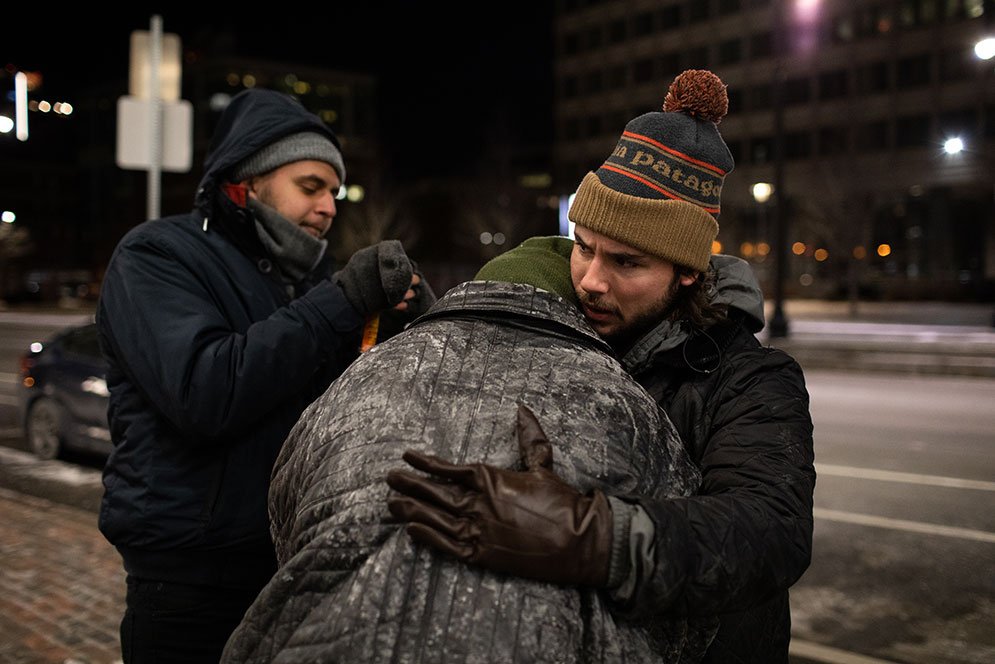 A City of Boston volunteer hugs a homeless person during the annual Boston Homeless Census.