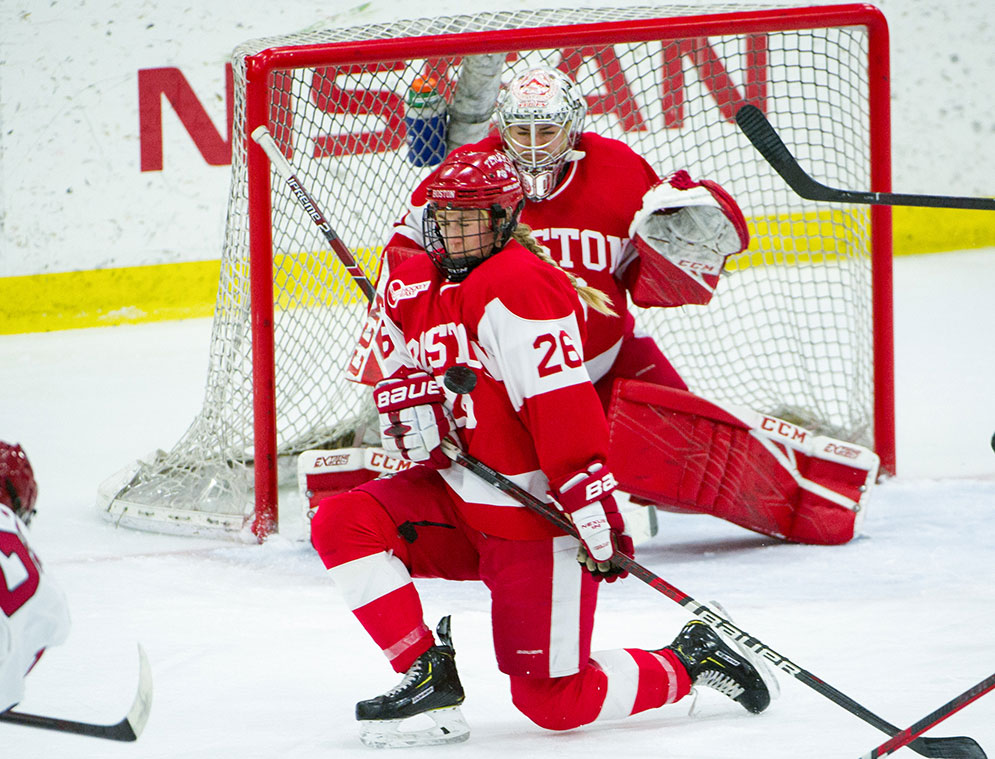 BU hockey player Connor Galway blocks a shot in front of the BU goal.