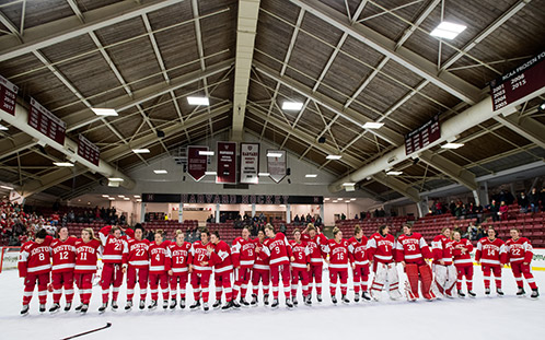 The BU women's ice hockey team lines up on the ice awaiting the presentation of the Beanpot trophy.