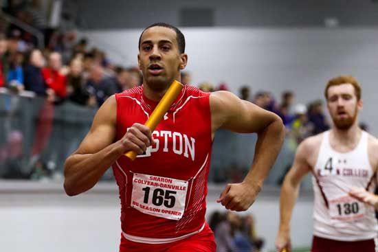 Sophomore sprinter Nikolas Smith holds a Baton while running