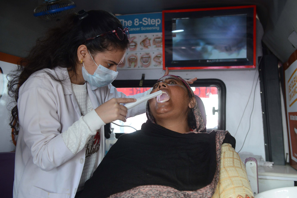 an Indian doctor screens a women for oral cancer