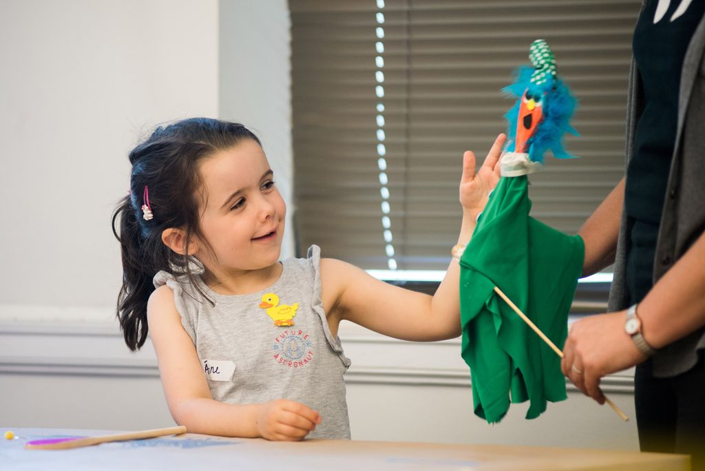 Aine, age 5, admires a stick puppet