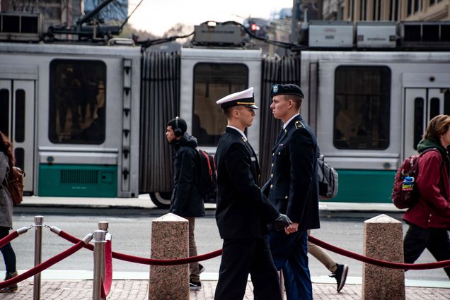 A photo of two students in Uniforms walking across Marsh Plaza as part of a Veteran'sDay Celebration.