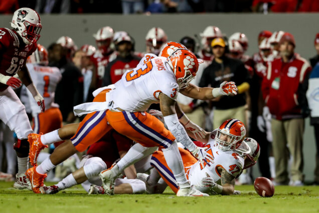 Clemson Tigers players watch as a fumbled ball touches the turf during an NCAA Football Game between the North Carolina State Wolfpack and the Clemson Tigers