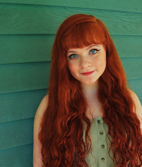 Portrait of Kelsie Garretson in front of a green wall