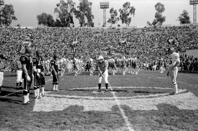 Captains from the San Diego State University and Boston University football teams participate in the coin toss before the 1969 Pasadena Bowl game.