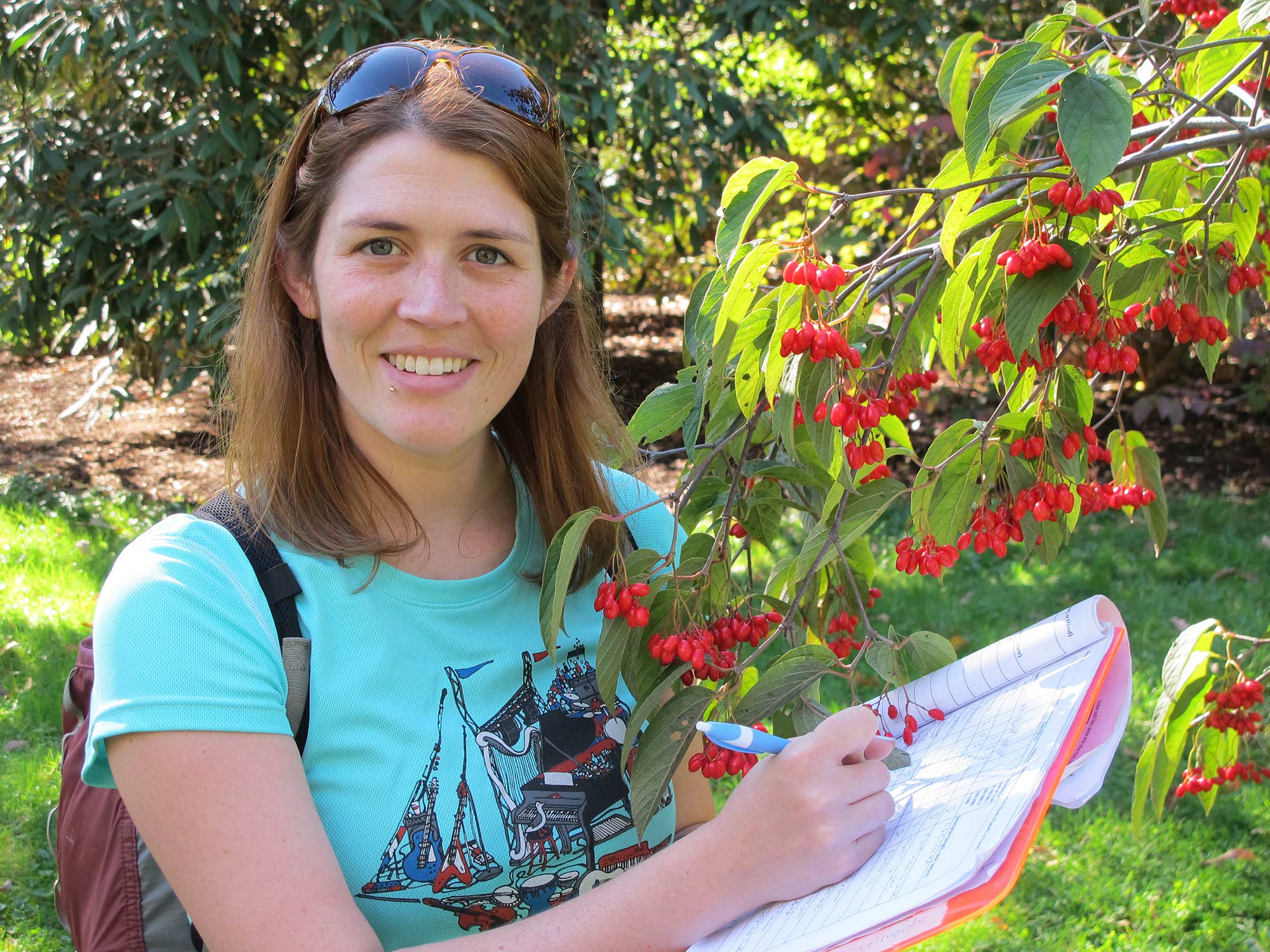 Ecological researcher Amanda Gallinat takes notes about tree fruit.