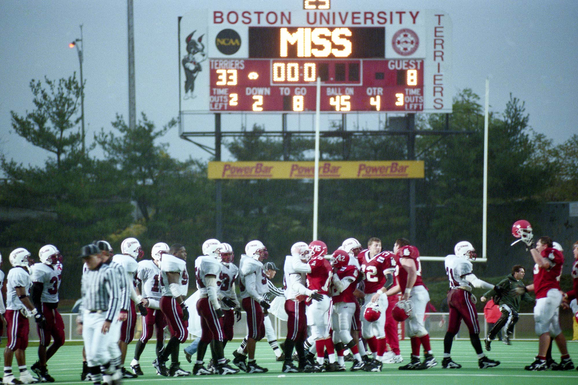 The Boston University football team shakes hands with the University of Massachusetts players following a 33 - 8 BU victory in the final BU football game.