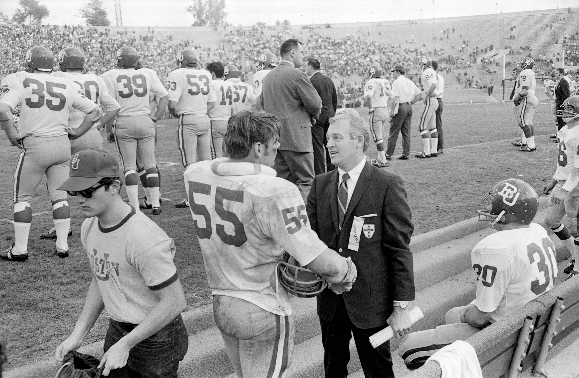 Boston University football player Pat Hughes (#55) talks to former Boston University president Arland F. Christ-Janer,on the sideline during the 1969 Pasadena Bowl.