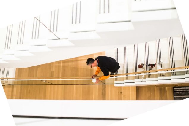 A photo of a man working on the staircase at the new Howard Thurman Center.