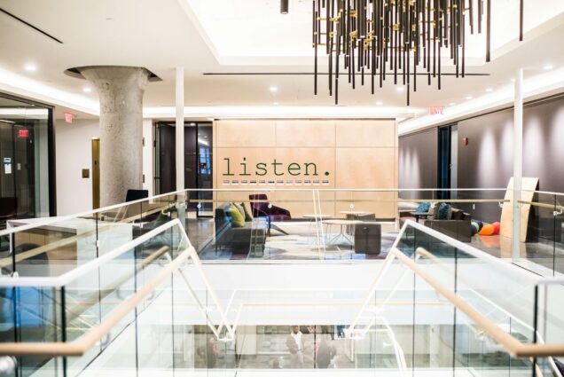 A view from the top of the staircase at the new Howard Thurman Center. Couches and chairs are visible in a sitting area in the background, and the word "listen" appears written on a wall.