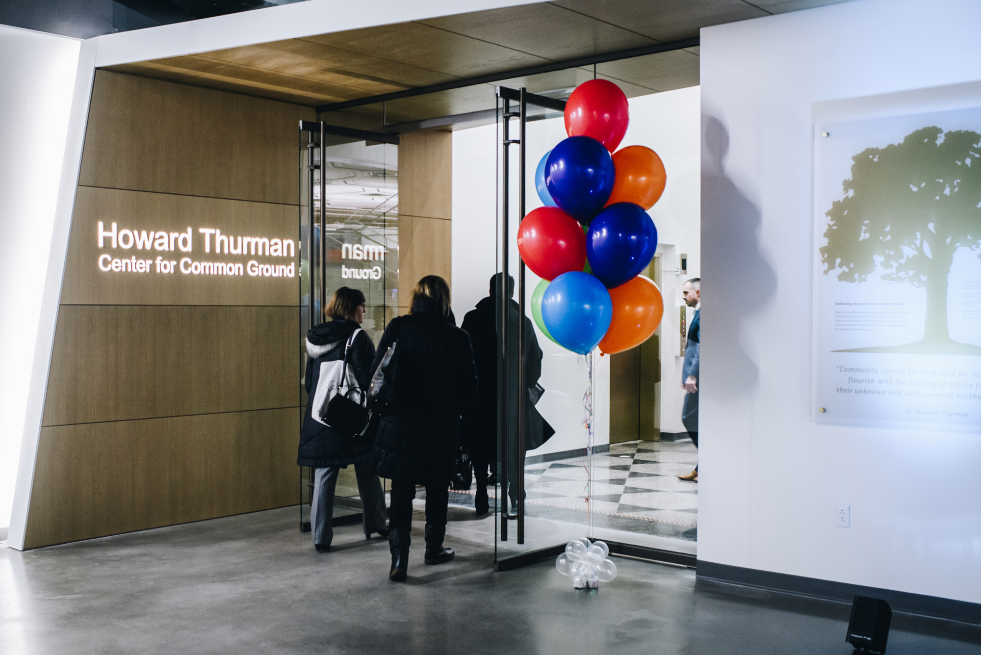 People walk into the brand new Howard Thurman Center during the grand opening. Colorful balloons mark the entrance.