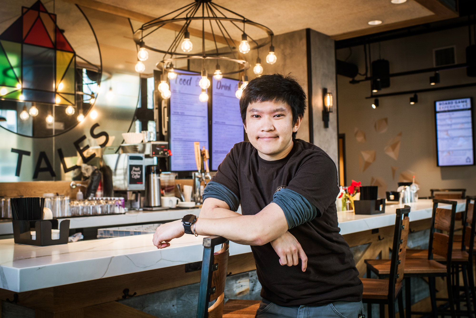 Nicholas Chen (CFA’17) poses for a photo inside his Board game café Tavern of Tales.