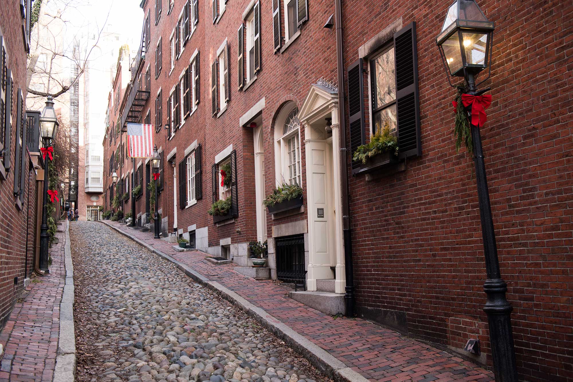 Uphill view of the brownstone houses and cobblestone street of Acorn Street, Beacon Hill, Boston.