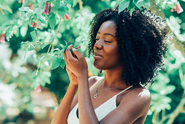 A photo of a woman smelling flowers