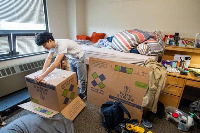 Photo of Chen-Yun “Jerry” Yang (CAS’23) packing up his things in his Claflin Hall dorm room; he plans to return home for the remainder of the semester.