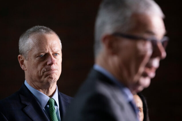 Massachusetts Gov. Charlie Baker, left, listens as CEO of the Boston Athletic Association Thomas Grilk talks about the postponement of the Boston Marathon during a news conference, Friday, March, 13, 2020,