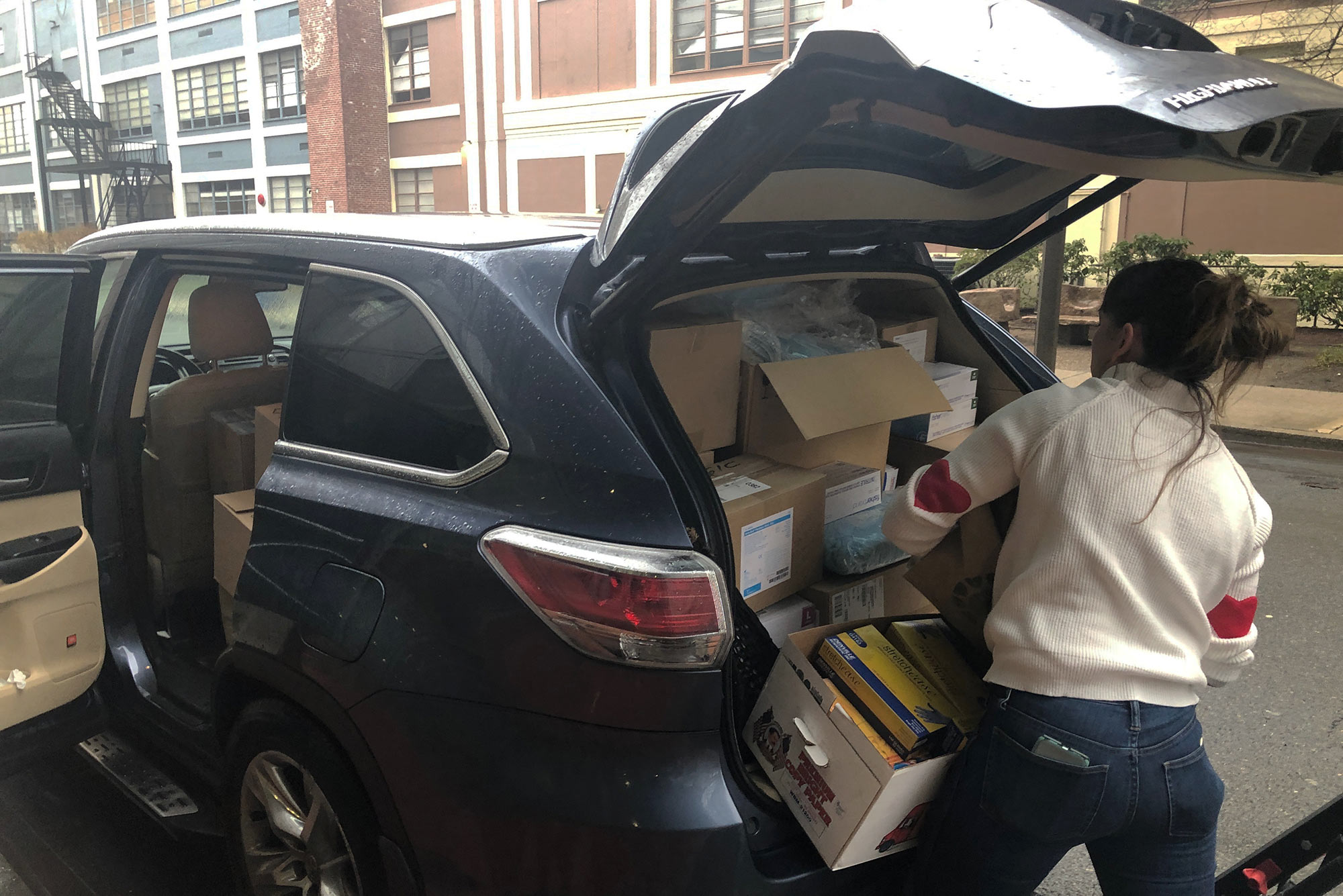A photo of supplies being loaded into the back of a car