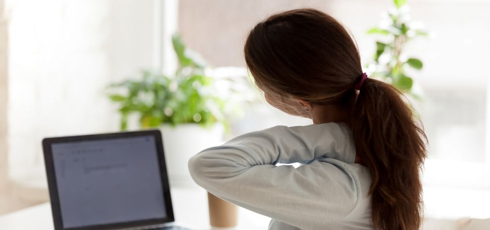 An image of a woman grabbing her neck in apparent discomfort