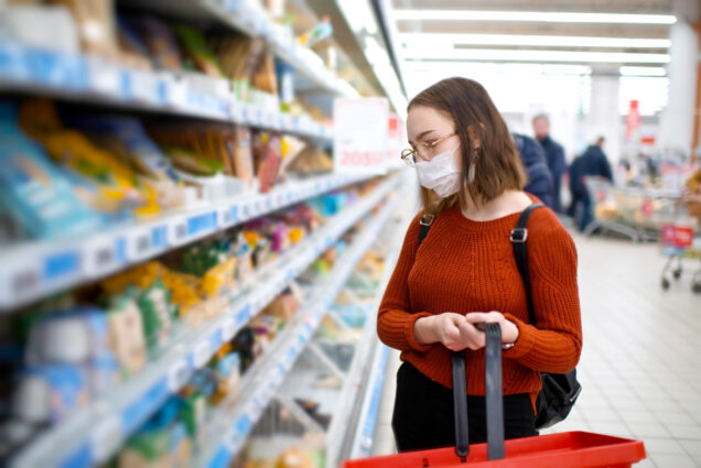 A photo of a woman grocery shopping in a mask
