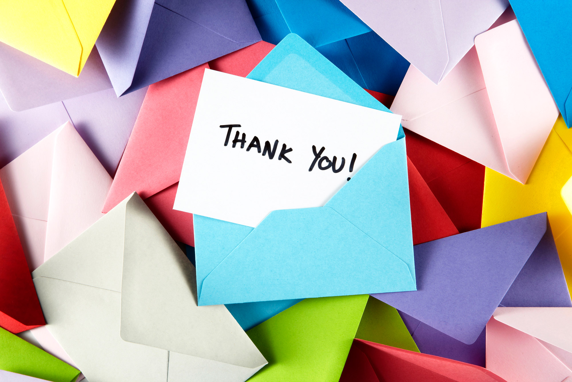 Image of a pile of colored envelopes with a note that says 'Thank You!' popping out of one.