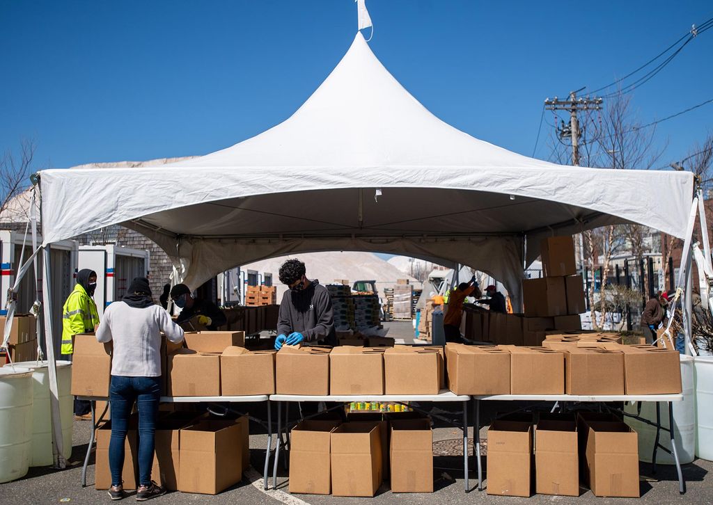 Image of Port Park, where food is sorted and packed for distributing on April 23, 2020. A big white tent with people and boxes is shown.