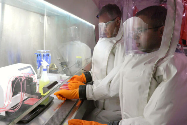 A photo of researchers working with COVID-19 in the NEIDL labs