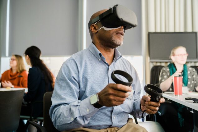 A photo of a person using a VR headset and hand controls