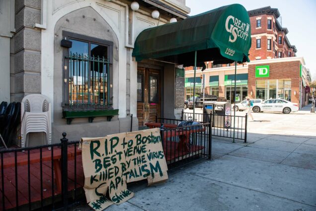 Photo of the exterior of Great Scott in Allston on May 4, 2020. The music venue is closing permanently after 44 years. A cardboard sign resting along the fence out front reads "RIP to Boston's best venue, killed by the virus of capitalism #rentstrike"