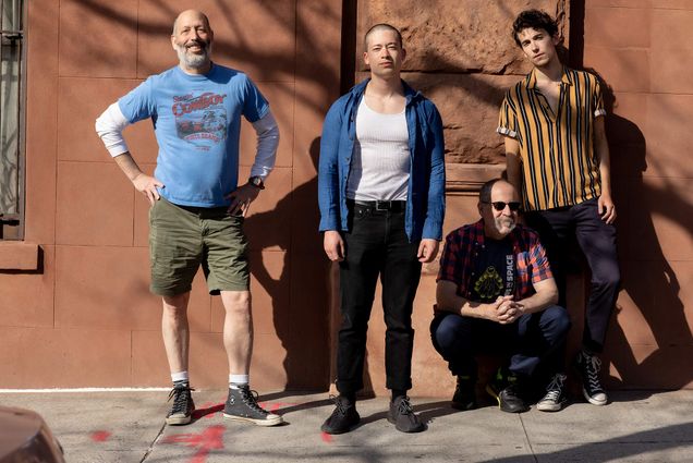 Photo of the stars of the siticom, The Social Distance, Michael Williams (from left), Quentin Nguyen-Duy (CFA’20), Lorin Sklamberg, and Julian Shapiro-Barnum (CFA’21). They group poses in front of a brown wall on the sidewalk.