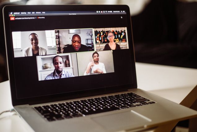 Photo of a computer with speakers from Boston University's Day of Collective Engagement to Reflect on American Racism, hosted on Zoom. On screen, Ibram X. Kendi, Paula Austin, Louis Chude-Sokei, and Saida Grundy as they speak during the opening plenary.