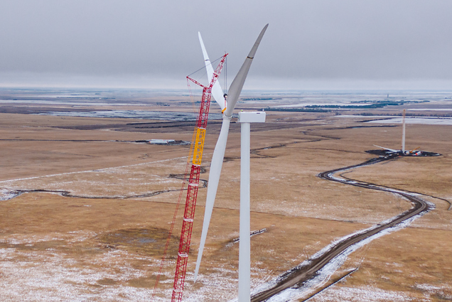 A photo of a wind turbine with a crane working on it