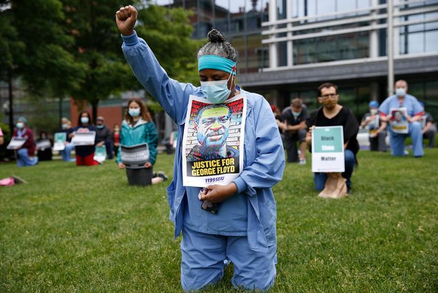 Image of Boston Medical Center staff holding a moment of silence on June 11th. Keila Price, pictured in blue scrubs, an Administrative Assistant at Boston Medical Center for 40 years, takes a knee alongside her fellow healthcare workers at BMC during an 8 minute 46 second moment of silence in memory of George Floyd and other members of the Black and brown community who have lost their lives to police violence.