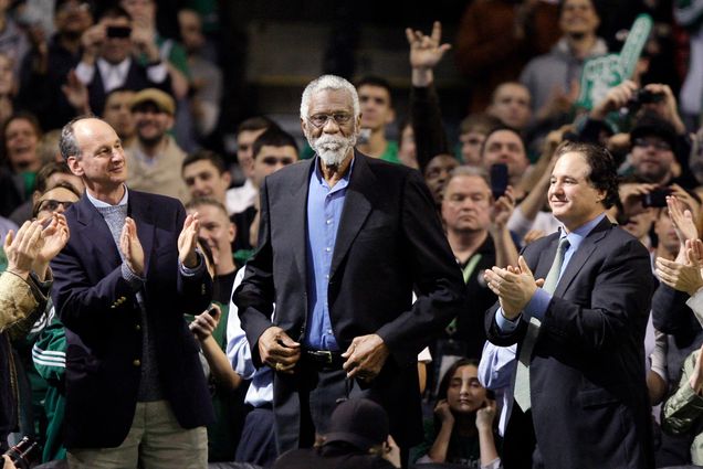 Photo of Former Boston Celtic Bill Russell, middle, receiving a standing ovation after being introduced prior to the Celtics' NBA basketball game against the Detroit Pistons in Boston, Wednesday, Feb. 15, 2012. Fans clap around Russell, who wears a suit jacket and blue button down.