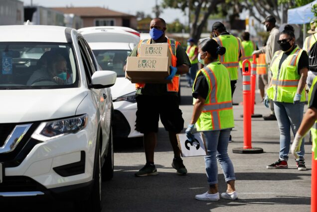 A photo of workers and volunteers loading up vehicles at a food distribution center in Compton, Calif.