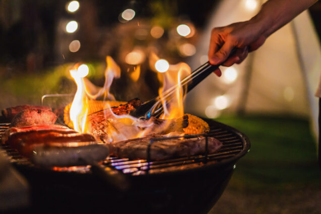 A photo of a person grilling outside