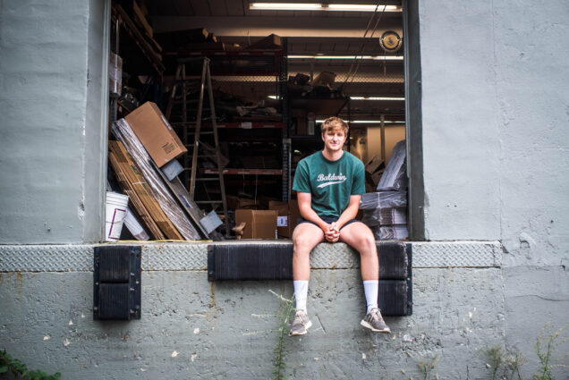 Will Paquin sits in the back of his father's autobody garage in West Newton