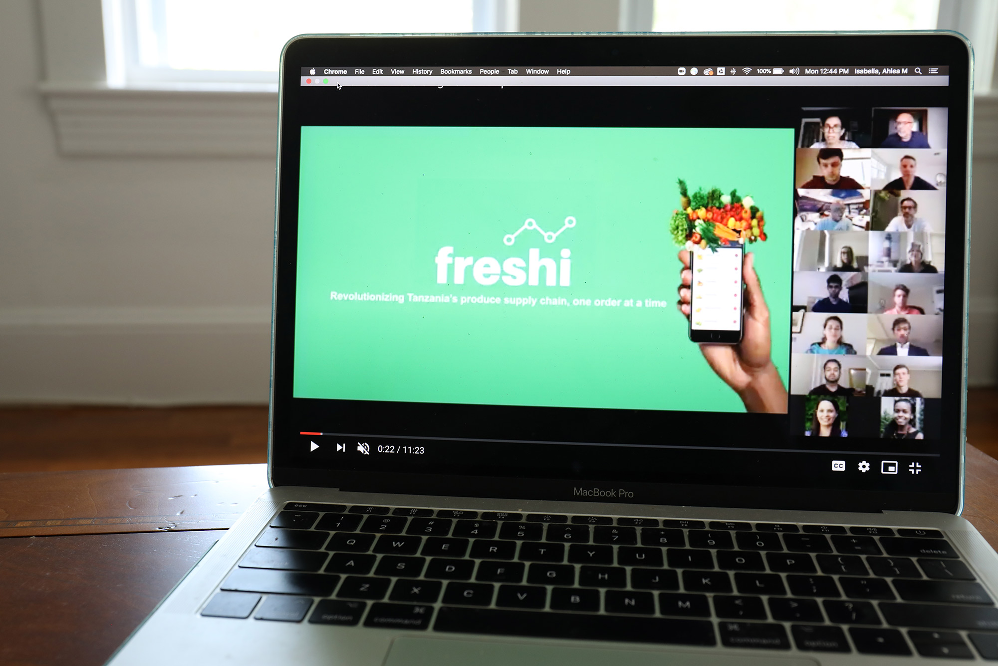 Photo of a laptop screen with a green website on screen with the words "Freshi," and a photo of cellphone with a grocery bag on top.