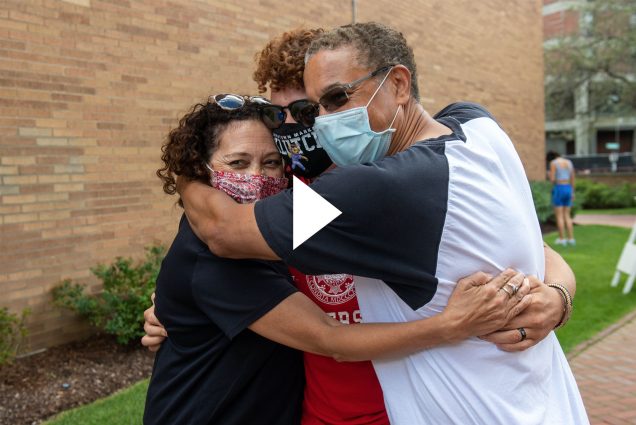 Angela Patterson, from left, Brendon Jones (CAS’24), and Walter Jones on West Campus move in August 28. The group hugs. Brendon and Walter wear sunglasses and Angela balances them on her head. Brendon wears a red BU shirt.