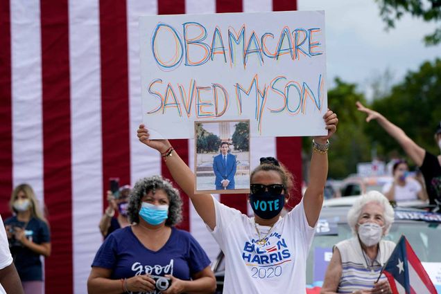 Adelys Ferro holds a sign in support of Obamacare at a Biden/Harris rally in Florida