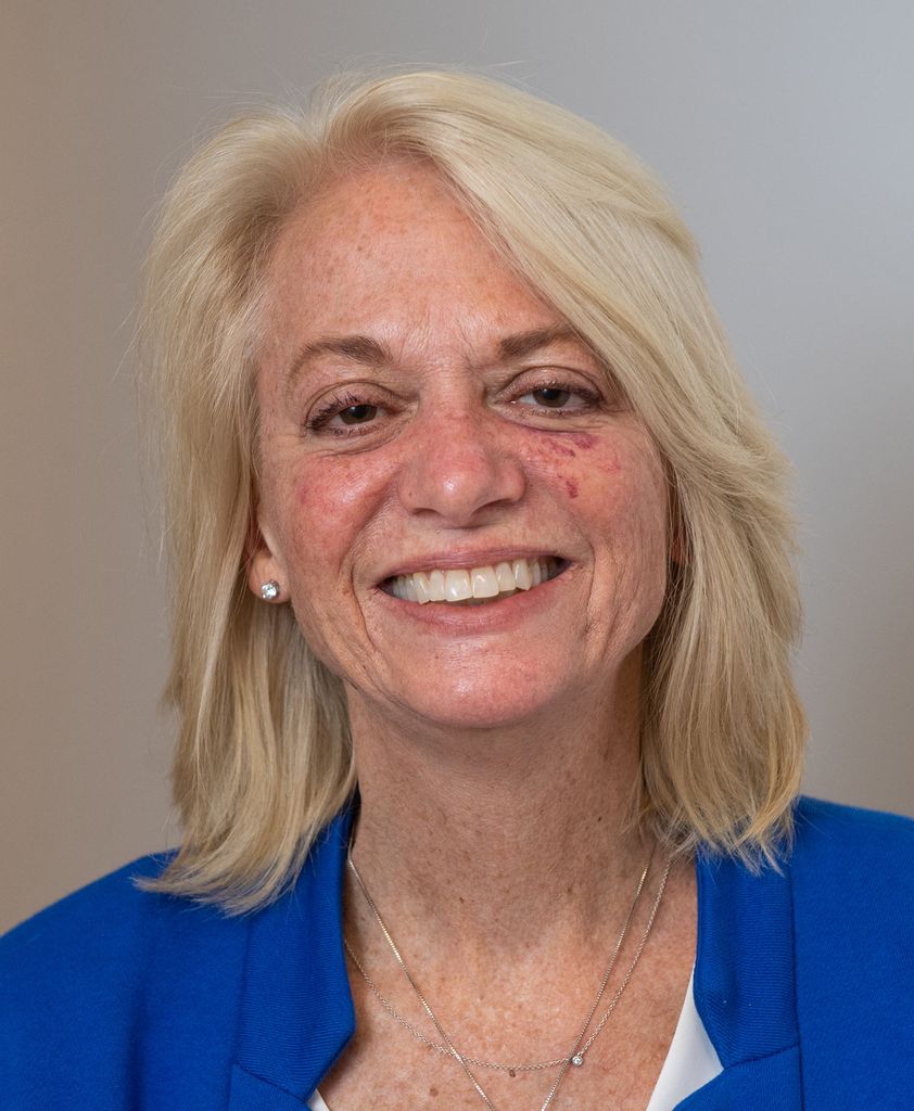 Headshot of Center for Stuttering Therapy Director Diane Constantino (Sargent’81). She smiles wide and wears a bright blue blazer.