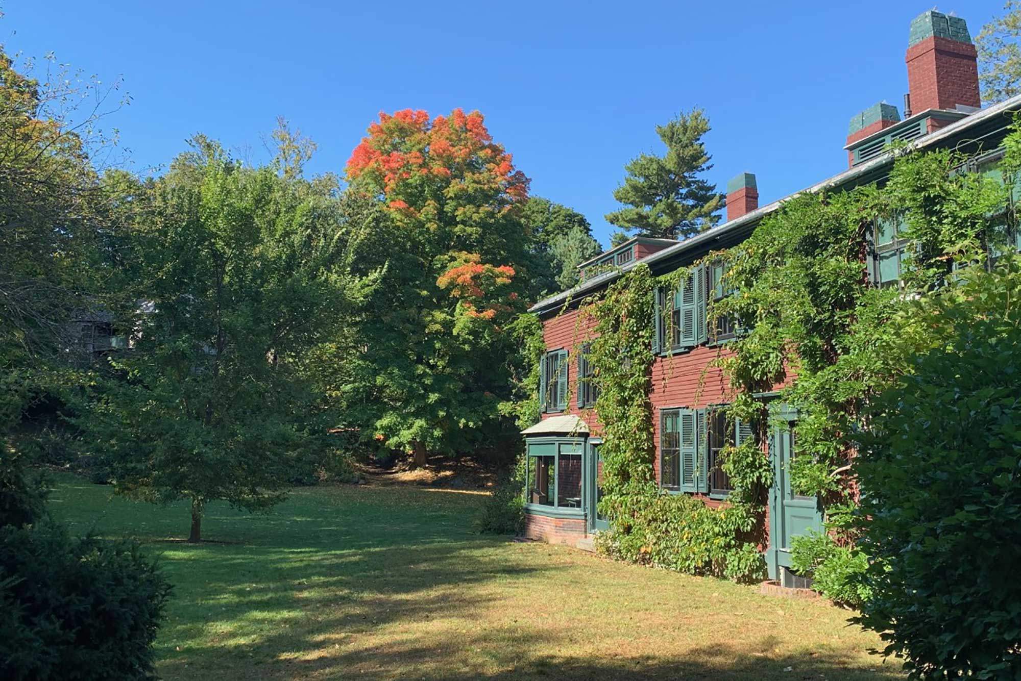 Photo of the old home of Frederick Law Olmsted in Brookline. The leaves on the trees behind the crimson-colored house are starting to turn.