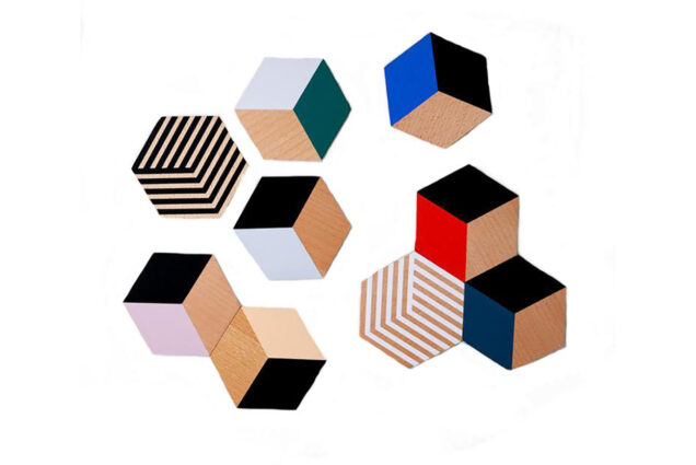 Photo of table tile coasters with colorful 3-D looking cube designs on a white background.